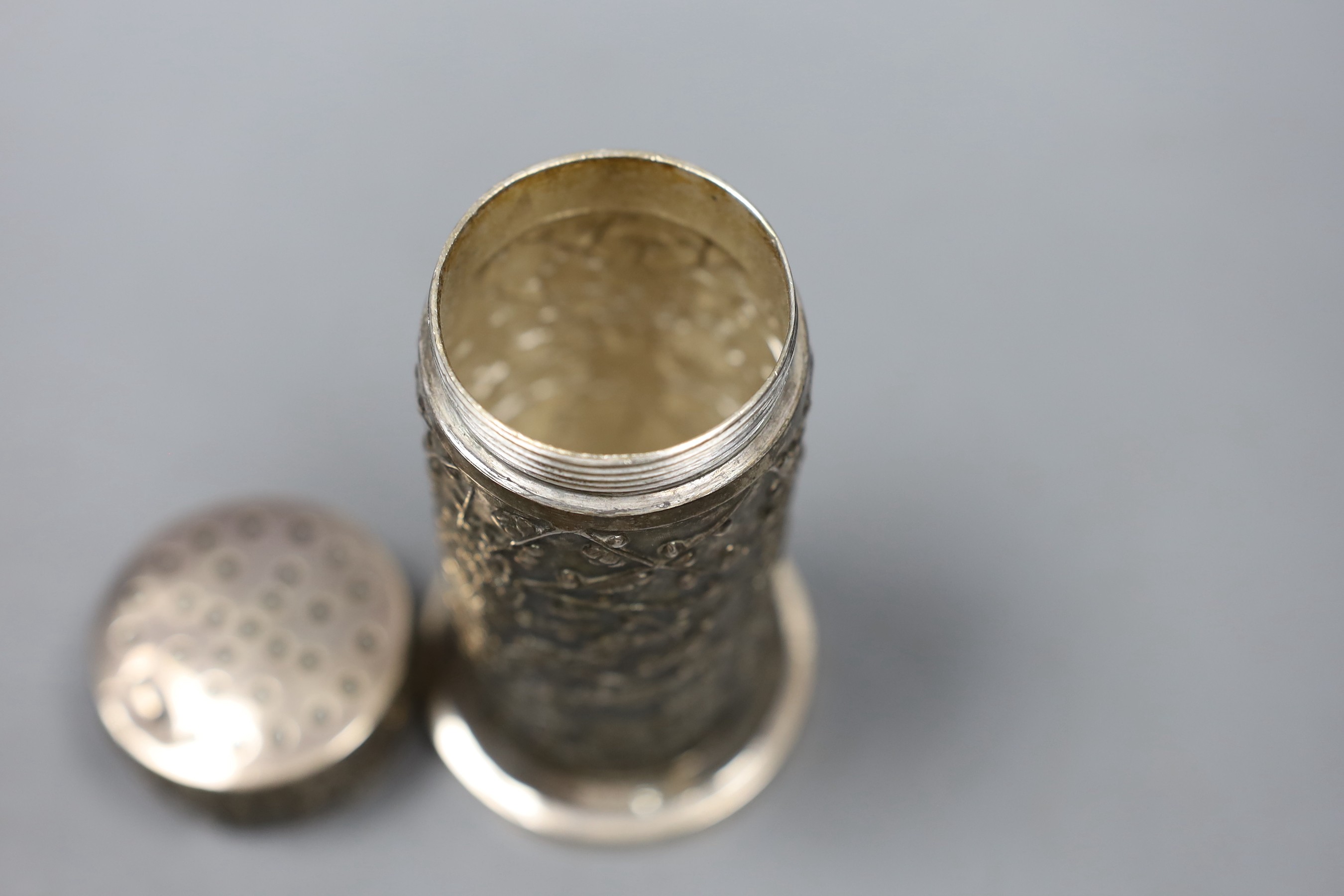 A late 19th/early 20th century Chinese Export white metal cylindrical sugar caster by Wang Hing, Hong Kong, decorated with prunus, 12.1cm, 170 grams.